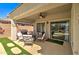 Cozy covered back patio with a grill, seating, and view of the backyard pool at 709 E Dry Creek Rd, San Tan Valley, AZ 85143