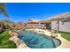 Lush backyard showcasing a private pool, landscaped with artificial turf, and a covered patio at 709 E Dry Creek Rd, San Tan Valley, AZ 85143