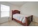 Cozy bedroom with a wood-frame bed, side table, and large window at 709 E Dry Creek Rd, San Tan Valley, AZ 85143