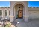 Close up of home's front entrance with decorative door, arched entryway, and charming outdoor seating at 709 E Dry Creek Rd, San Tan Valley, AZ 85143