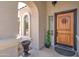 Covered entryway with a decorative door, arched columns, and accent lighting at 709 E Dry Creek Rd, San Tan Valley, AZ 85143