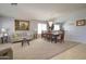 Spacious living and dining area featuring plush carpeting, elegant chandelier, and neutral décor at 709 E Dry Creek Rd, San Tan Valley, AZ 85143