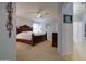 Spacious main bedroom with soft carpet, ceiling fan, and access to the bathroom at 709 E Dry Creek Rd, San Tan Valley, AZ 85143