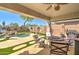 Relaxing covered patio with a fan, seating, and view of the backyard pool at 709 E Dry Creek Rd, San Tan Valley, AZ 85143