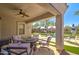 Inviting covered patio with fan, seating area, and a clear view of the pool at 709 E Dry Creek Rd, San Tan Valley, AZ 85143