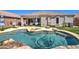Backyard oasis featuring a private pool, lounging area, and manicured landscaping with artificial turf at 709 E Dry Creek Rd, San Tan Valley, AZ 85143