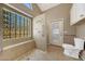 Accessible bathroom featuring walk-in shower with bench, grab bars and glass block window at 742 E Kyle Dr, Gilbert, AZ 85296