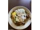 Close-up of a savory breakfast dish topped with eggs, cheese, and a creamy sauce at 742 E Kyle Dr, Gilbert, AZ 85296
