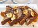 Close-up of french toast covered in banana, walnuts, syrup and powdered sugar at 742 E Kyle Dr, Gilbert, AZ 85296