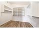 Walk-in closet features wood-look floors and built-in shelving and hanging racks at 742 E Kyle Dr, Gilbert, AZ 85296