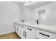 Bright bathroom featuring double sinks with white cabinets and stone countertops with black hardware at 8137 W Pueblo Ave, Phoenix, AZ 85043
