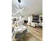 Open concept living room features a modern light fixture, chairs, kitchen, island and television at 8137 W Pueblo Ave, Phoenix, AZ 85043