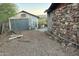 Exterior featuring a stone house, adjacent to a weathered metal shed, capturing a rustic and functional outdoor space at 829 W Spray St, Superior, AZ 85173