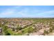 Aerial view showcases neighborhood, green park areas, golf course, and city skyline in the distance at 8920 S 40Th Ln, Laveen, AZ 85339