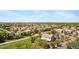 Wide aerial shot showcasing a neighborhood with green spaces and a distant city skyline at 8920 S 40Th Ln, Laveen, AZ 85339