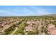 Aerial view of a well-maintained residential area featuring green belts and nearby golf course at 8920 S 40Th Ln, Laveen, AZ 85339