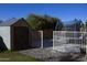 View of backyard shed, trampoline, and gravel landscaping, all enclosed by a white-gated fence at 8920 S 40Th Ln, Laveen, AZ 85339