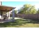 This view shows the backyard with a covered patio and a large grassy area at 8920 S 40Th Ln, Laveen, AZ 85339