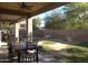 Covered backyard patio with ceiling fan, outdoor dining set, and view of the yard, perfect for outdoor relaxation at 8920 S 40Th Ln, Laveen, AZ 85339