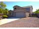 Side view of two-story home showing garage and side yard with mature landscaping at 8920 S 40Th Ln, Laveen, AZ 85339
