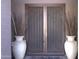 Close up of front doors with potted plants and unique ironwork at 8920 S 40Th Ln, Laveen, AZ 85339