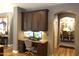 Convenient home office area built-in to the kitchen with desk, brown cabinets, and lighting at 8920 S 40Th Ln, Laveen, AZ 85339