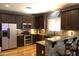 Well-equipped kitchen with stainless steel appliances and breakfast bar with attractive stone accents at 8920 S 40Th Ln, Laveen, AZ 85339