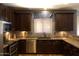 Beautiful kitchen featuring brown cabinets, a stainless steel dishwasher, and lots of counter space at 8920 S 40Th Ln, Laveen, AZ 85339