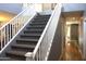 Carpeted staircase with white railing and neutral wall colors at 8920 S 40Th Ln, Laveen, AZ 85339