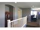 Upstairs hallway with neutral tones, leading to various rooms and featuring a stylish accent table with floral arrangement at 8920 S 40Th Ln, Laveen, AZ 85339