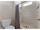 Tiled bathroom with shower, toilet, and window at 9550 E Thunderbird Rd # 214, Scottsdale, AZ 85260