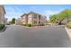 Multi-level residential building featuring neutral color scheme, desert landscaping, and an adjacent parking lot at 9550 E Thunderbird Rd # 214, Scottsdale, AZ 85260