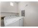 Well-lit laundry room featuring a white washer and dryer set, and ample shelving space above at 9550 E Thunderbird Rd # 214, Scottsdale, AZ 85260