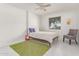 Neutral bedroom with a wood-frame bed, guitar, green rug, and gray chair at 9623 N 34Th Pl, Phoenix, AZ 85028