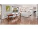 Bright dining area featuring a stylish light fixture, rustic table, and modern white chairs for a cozy gathering space at 9623 N 34Th Pl, Phoenix, AZ 85028
