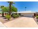 Well-maintained house with a spacious driveway, landscaping, and palm trees at 9623 N 34Th Pl, Phoenix, AZ 85028