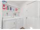 Functional laundry room with white washer and dryer, complemented by convenient shelving for storage at 9623 N 34Th Pl, Phoenix, AZ 85028