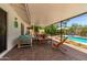 Spacious covered patio with cozy furniture, offering serene views of the pool and well-maintained backyard at 9623 N 34Th Pl, Phoenix, AZ 85028