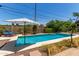 Refreshing pool area with lounge chairs, an umbrella for shade, and tidy desert landscaping at 9623 N 34Th Pl, Phoenix, AZ 85028