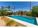 Sparkling pool with a sun umbrella, surrounded by comfortable lounge chairs, with desert landscaping at 9623 N 34Th Pl, Phoenix, AZ 85028