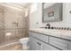 Modern bathroom featuring a glass-enclosed shower, white vanity with gray cabinets, and a decorative mirror at 9753 E Suncrest Rd, Scottsdale, AZ 85262
