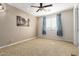 Cozy bedroom with neutral walls, carpet flooring, a ceiling fan, and a bright window with blue curtains at 9753 E Suncrest Rd, Scottsdale, AZ 85262