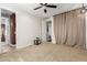 Carpeted bedroom featuring a ceiling fan, beige walls, neutral carpet, and multiple doorways at 9753 E Suncrest Rd, Scottsdale, AZ 85262