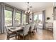 Sunlit dining room with large windows, stylish chandelier, and inviting gray upholstered seating at 9753 E Suncrest Rd, Scottsdale, AZ 85262