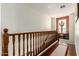 Hallway with wooden railing, hardwood floors, and natural light showcasing decorative Southwest style cactus at 9753 E Suncrest Rd, Scottsdale, AZ 85262