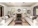 Cozy living room with twin sofas, decorative fireplace, and natural light from two windows at 9753 E Suncrest Rd, Scottsdale, AZ 85262