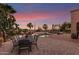 A comfortable outdoor dining area with a beautiful pool and desert landscaping, offering a serene outdoor living space at 9753 E Suncrest Rd, Scottsdale, AZ 85262