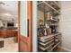 Walk-in pantry with adjustable metal shelving, sliding wood door, and convenient storage solutions at 9753 E Suncrest Rd, Scottsdale, AZ 85262