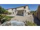 Expansive backyard features a covered patio, desert landscaping, and a charming rock water feature at 1031 W Longhorn Dr, Chandler, AZ 85286