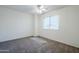 Bright bedroom featuring neutral carpet, a ceiling fan, and a window for natural light at 1031 W Longhorn Dr, Chandler, AZ 85286